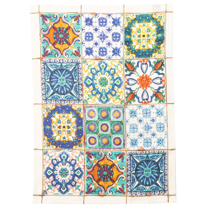 A tea towel featuring a collection of square Italian tiles with various floral and geometric patterns in a variety of colors including blue, green, yellow, and white.