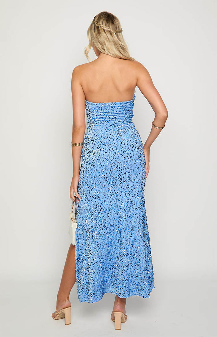 Back view of a blue sequin strapless maxi dress featuring a ruched bodice and a high leg slit